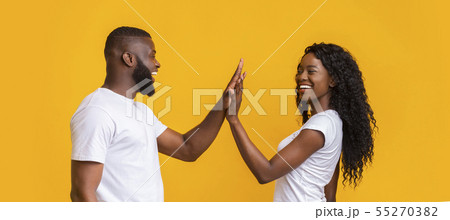 Cheerful man and woman giving each other high five 55270382