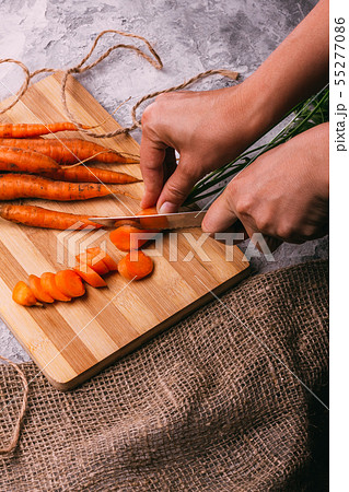 Women's hands cut carrots for salad Women's hands cut carrots for salad 55277086