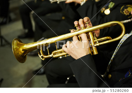 The trumpeter is playing on a silver trumpet. Trumpet players 55280260