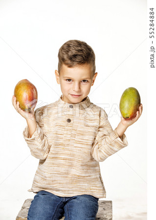 handsome pretty boy is holding a mango handsome pretty boy is holding a mango 55284884