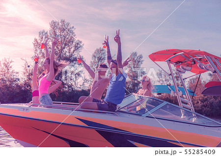 Cheerful pleased modern young people celebrating in the company of their friends Cheerful pleased modern young people celebrating in the company of their friends 55285409
