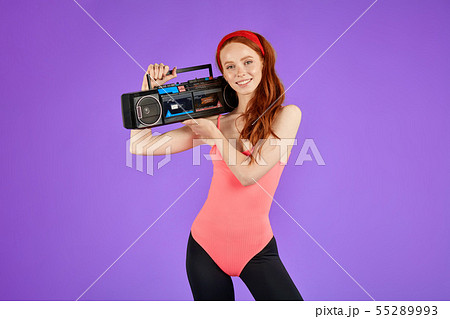 view of athletic girl with red hair and fit body, stands with portable audio player view of athletic girl with red hair and fit body, stands with portable audio player 55289993