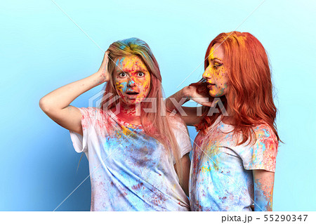 shocked blonde girl looking at the camera while standing near her friend 55290347