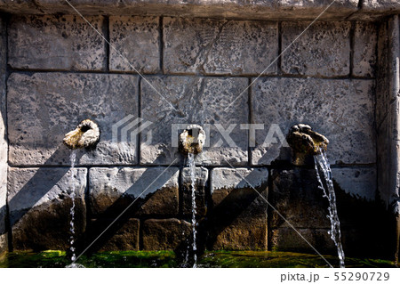 Three stone taps from which water flows 55290729