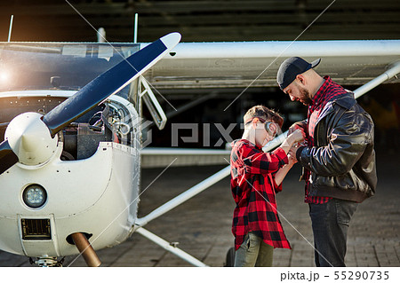 boy and his big stand near propeller airplane, assemble toy plane together boy and his big stand near propeller airplane, assemble toy plane together 55290735