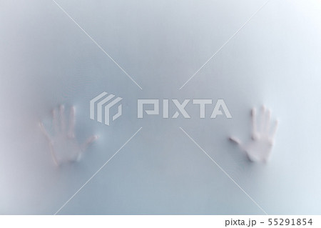 Shadow of hand. palms behind frosted glass representing dangerous 55291854