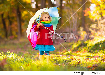 Kid with umbrella playing in autumn rain. Kid with umbrella playing in autumn rain. 55292028