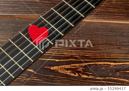 Guitar fretboard with red heart. 55299417