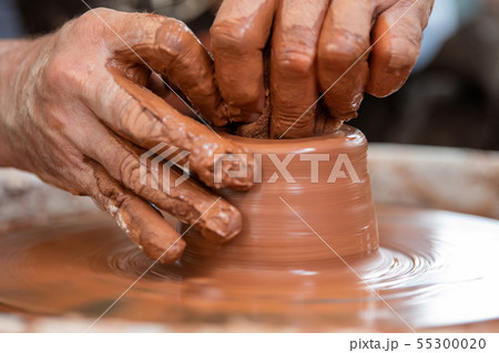 Potter makes pottery dishes on potter's wheel Potter makes pottery dishes on potter's wheel 55300020