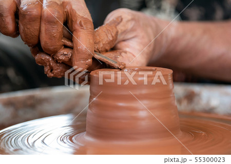 Potter makes pottery dishes on potter's wheel 55300023