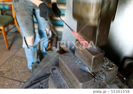 Blacksmith forging by using pneumatic hammer. Blacksmith forging by using pneumatic hammer. 55301556