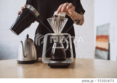 Close up of a barista making hand brewed coffee. Close up of a barista making hand brewed coffee. 55301673