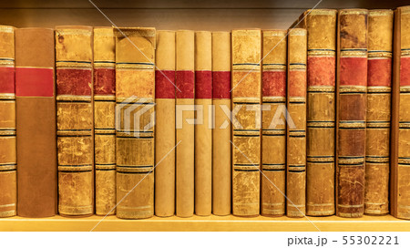 Antique books on wooden bookshelf in library 55302221