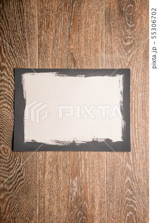 Black painted frame on white paper on wooden 55306702