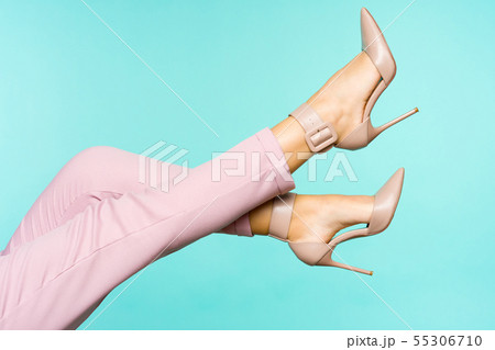 Sexy legs in brown high heels shoes on blue Sexy legs in brown high heels shoes on blue 55306710