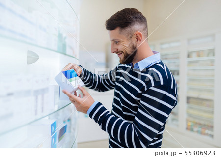 Delighted visitor standing near shelves with medicine Delighted visitor standing near shelves with medicine 55306923