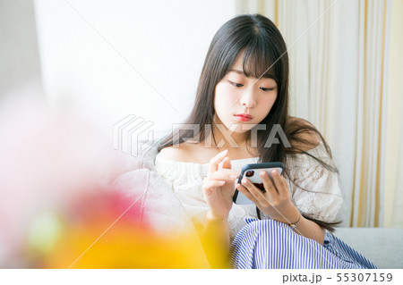 部屋でスマホを使う若い女の子 55307159