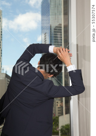 窓際でストレッチをしている男性 55307574