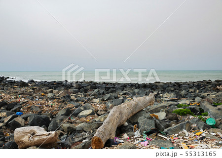 Spilled garbage on the beach near the big city. Empty used dirty plastic bottles and other garbage Spilled garbage on the beach near the big city. Empty used dirty plastic bottles and other garbage 55313165