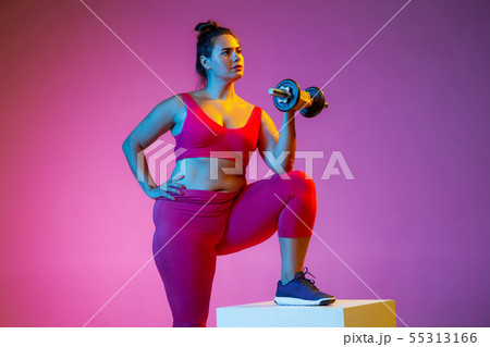 Young caucasian plus size female model's training on gradient background 55313166
