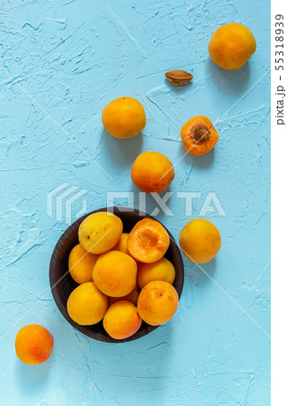 Ripe apricots in a black wooden bowl. 55318939