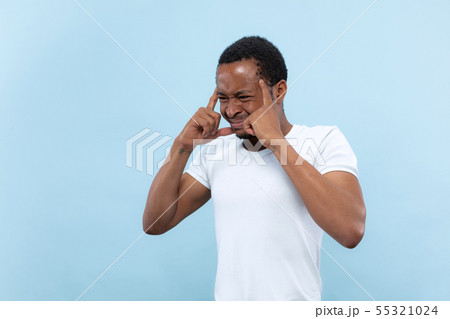 Half-length close up portrait of young man on blue background. Half-length close up portrait of young man on blue background. 55321024