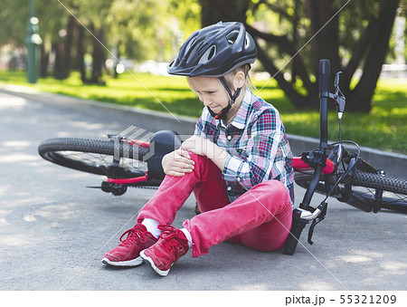 Crying girl is sitting next to her bike 55321209