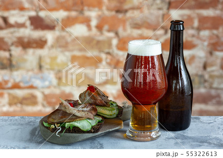 Glass of beer on the stone table and brick's background 55322613
