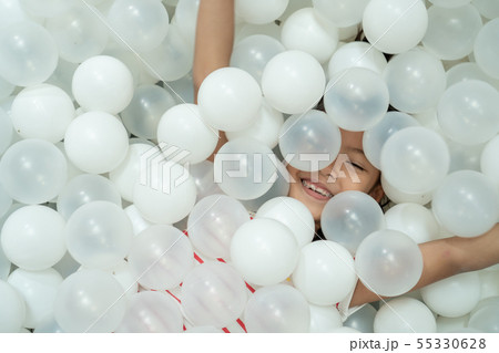 asian child girl play with white plastic balls asian child girl play with white plastic balls 55330628