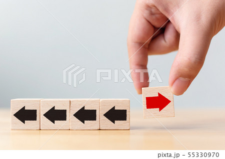 Hand holding wooden block with red arrow facing Hand holding wooden block with red arrow facing 55330970