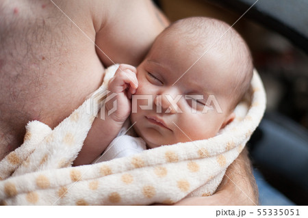 Young father holding his sweet adorable sleeping newborn child Young father holding his sweet adorable sleeping newborn child 55335051