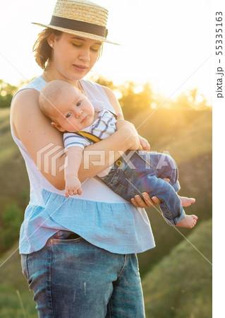 Mom with baby spending time together at sunset, on summer  55335163