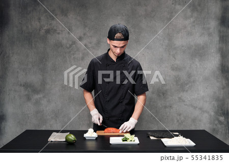 Chef man in the kitchen at the restaurant. Ingredients for sushi and rolls. Chef man in the kitchen at the restaurant. Ingredients for sushi and rolls. 55341835