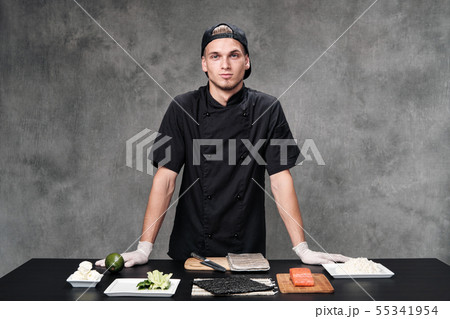 Chef man in the kitchen at the restaurant. Ingredients for sushi and rolls. Chef man in the kitchen at the restaurant. Ingredients for sushi and rolls. 55341954