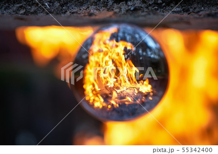 Upside down view through the lensball on blurred campfire in forest 55342400