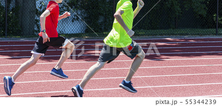 Two young boys running fast on a track Two young boys running fast on a track 55344239