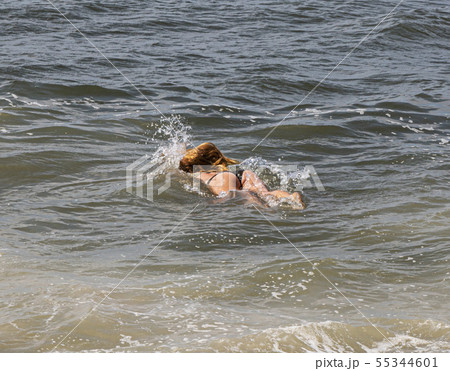 Redheaded yound lady as she enters the water from Redheaded yound lady as she enters the water from 55344601