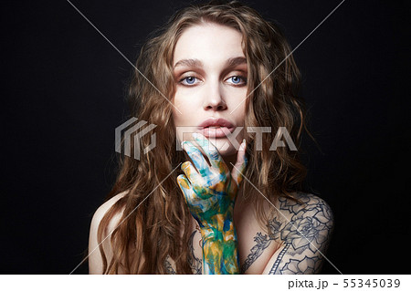 Young Woman with Tattoo and color paint on her Young Woman with Tattoo and color paint on her 55345039