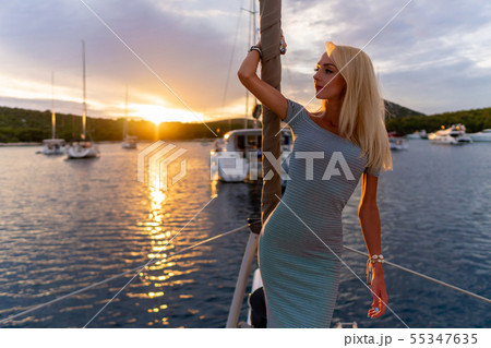 beautiful sexy woman in dress relaxing on a yacht front at sunset beautiful sexy woman in dress relaxing on a yacht front at sunset 55347635