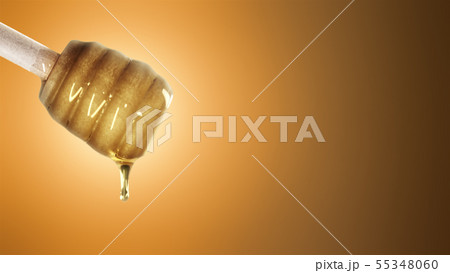 Honey dripping from honey dipper on orange background Honey dripping from honey dipper on orange background 55348060