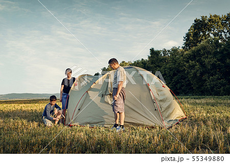 Family set up tent camp at sunset, beautiful 55349880