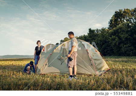 Family set up tent camp at sunset, beautiful 55349881