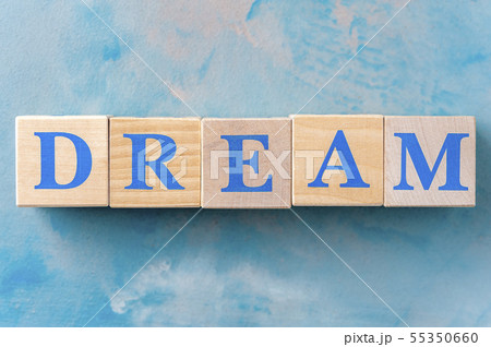 Wooden cubes with word DREAM on blue table. Wooden cubes with word DREAM on blue table. 55350660