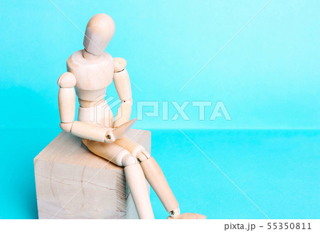 Wooden human figure on a blue background. The Wooden human figure on a blue background. The 55350811