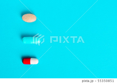 White red capsules, pills on a blue background. White red capsules, pills on a blue background. 55350851