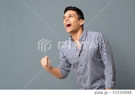 Happy Arab Guy Shaking Clenched Fist On Gray Background Happy Arab Guy Shaking Clenched Fist On Gray Background 55350998