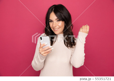 Woman with happy face holding phone and getting good news isolated. 55351721