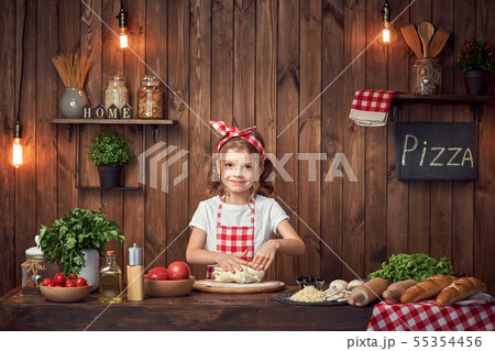 Pretty girl in checkered apron kneading bread dough for pizza Pretty girl in checkered apron kneading bread dough for pizza 55354456