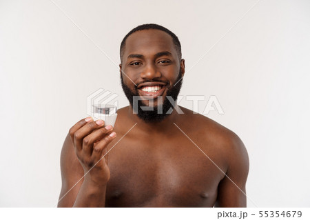 shirtless young brutal african american man applying facial cream on his face. close up portrait,men shirtless young brutal african american man applying facial cream on his face. close up portrait,men 55354679