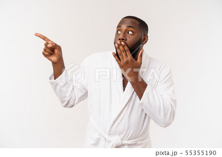 Black guy wearing a bathrobe pointing finger with surprise and happy emotion. Isolated over whtie 55355190